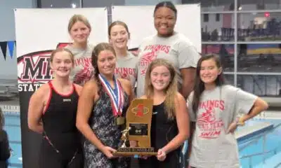 Warren Central girls' swim team celebrating with a trophy after finishing as state runner-up.