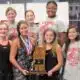 Warren Central girls' swim team celebrating with a trophy after finishing as state runner-up.