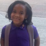 Paris Morris smiling in a purple school uniform with a backpack