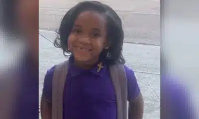 Paris Morris smiling in a purple school uniform with a backpack