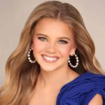 Bryleigh Landers smiles in a blue dress and pearl earrings in a pageant portrait.