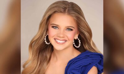 Bryleigh Landers smiles in a blue dress and pearl earrings in a pageant portrait.