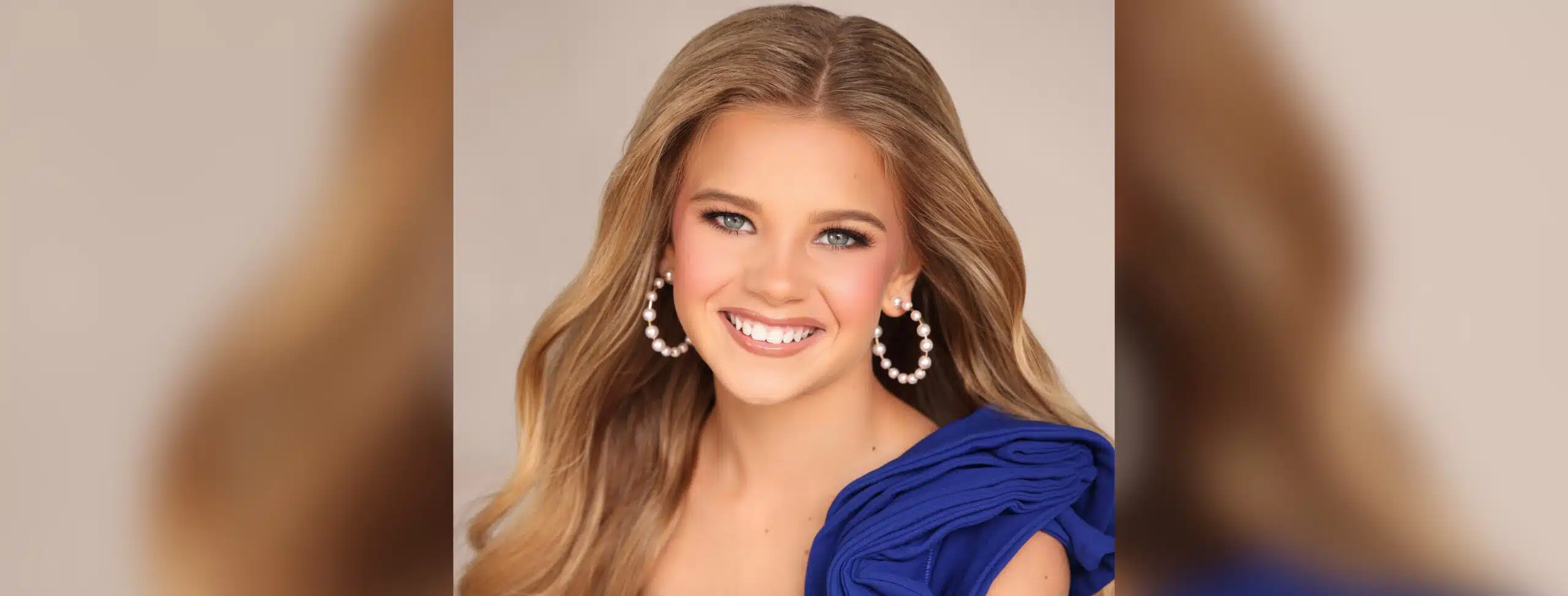 Bryleigh Landers smiles in a blue dress and pearl earrings in a pageant portrait.