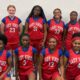 Warren Central Junior girls basketball players pose in red Lady Vikes uniforms inside a gym.