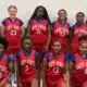 Warren Central Junior girls basketball players pose in red Lady Vikes uniforms inside a gym.