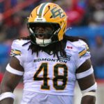 Nick Anderson overcomes injuries as an Edmonton Elks linebacker in a white No. 48 uniform and yellow helmet on the field.