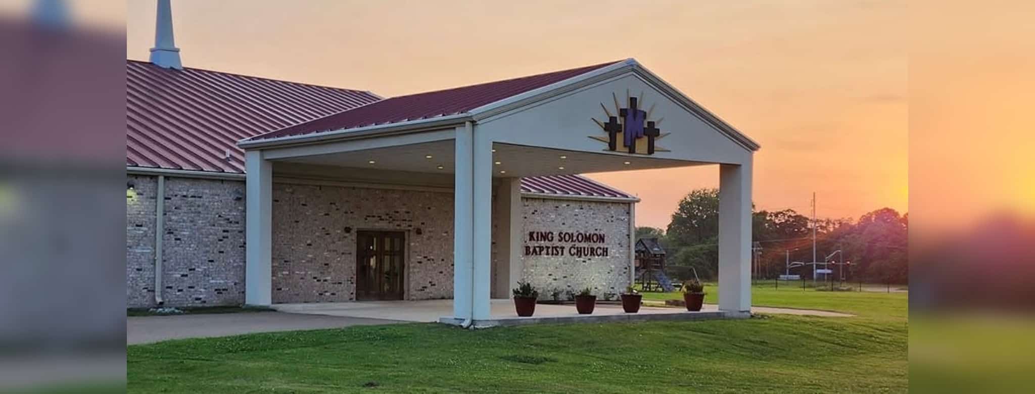 King Solomon Baptist Church entrance and sign on a green lawn at sunset