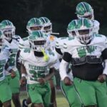Vicksburg Gators football team running onto the field in green and wh — Gators take a 15-12 heartbreaking loss to Florence
