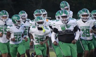 Vicksburg Gators football team running onto the field in green and wh — Gators take a 15-12 heartbreaking loss to Florence
