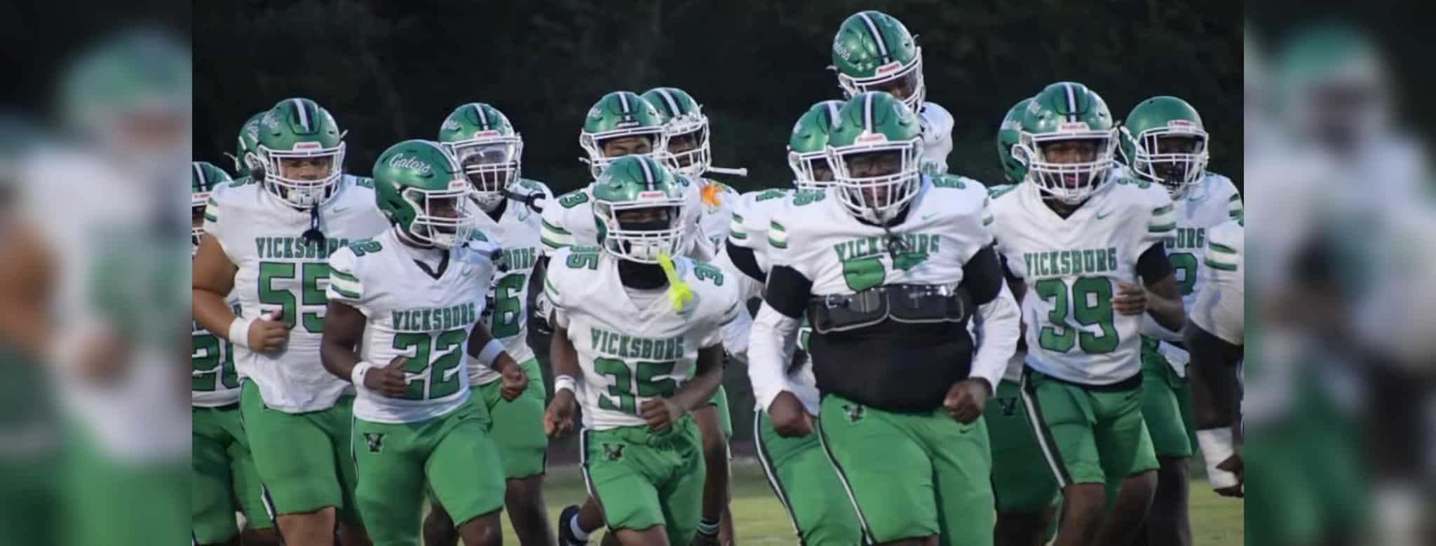 Vicksburg Gators football team running onto the field in green and wh — Gators take a 15-12 heartbreaking loss to Florence