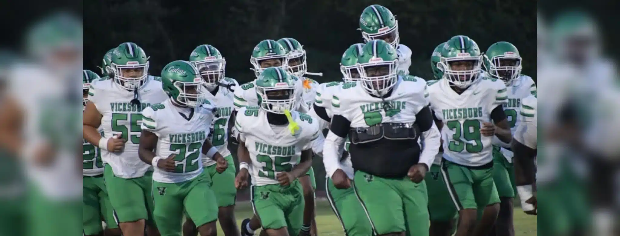 Vicksburg Gators football team running onto the field in green and wh — Gators take a 15-12 heartbreaking loss to Florence