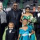 To’Nia Taylor homecoming queen in a turquoise gown poses with family members on the football field.