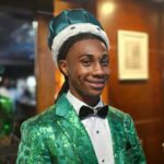 Jordan Clay homecoming king in a green patterned suit, bow tie and crown