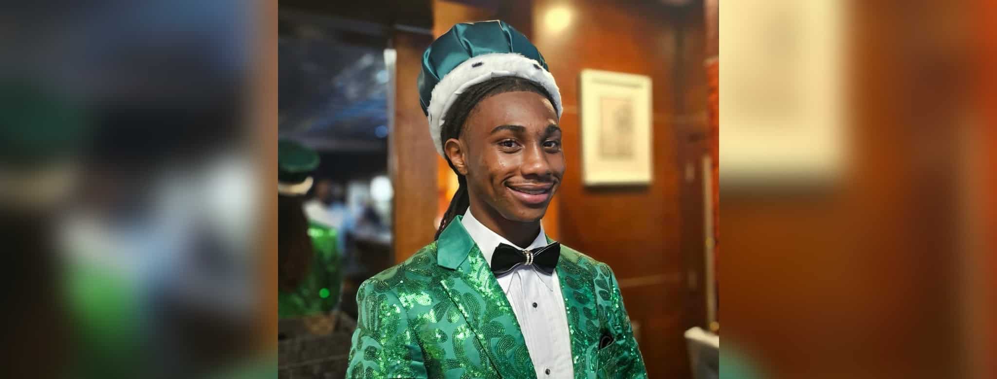 Jordan Clay homecoming king in a green patterned suit, bow tie and crown